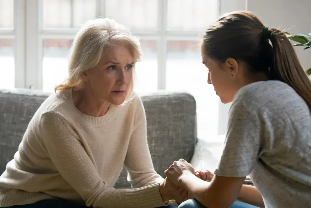 Older Woman and Daughter holding hands, in discussion about parent's divorce.